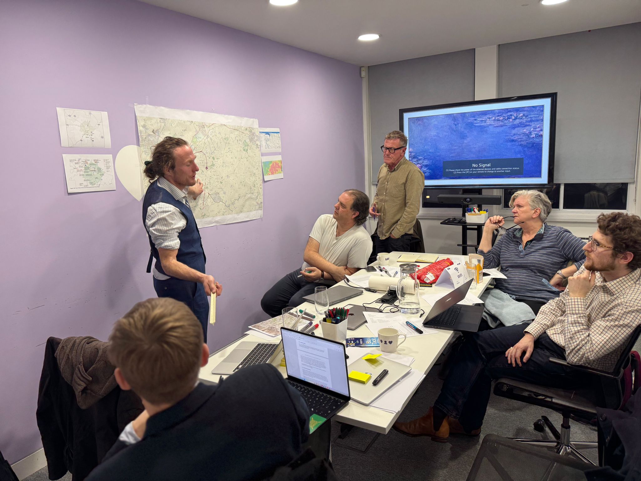 Forest City planning meeting with team members reviewing maps and spatial plans